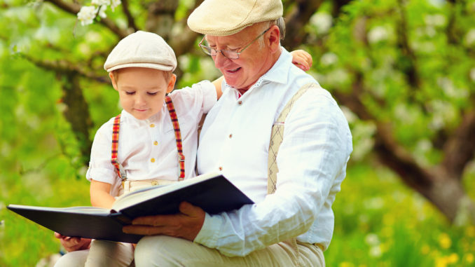 grandfather with grandson reading book in spring garden abuelo y nieto